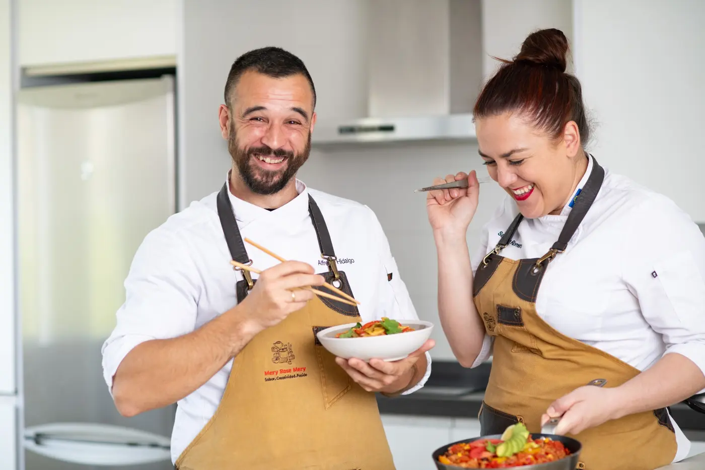 Mery and Alfredo laughing together while cooking