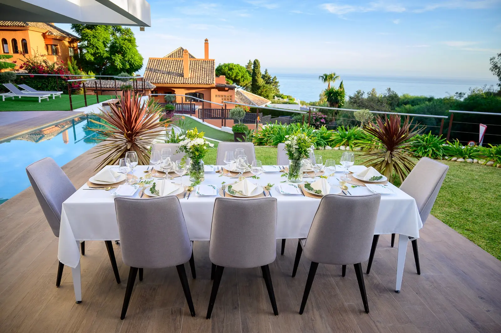 A long elegant table prepared beside a Marbella villa pool for an intimate wedding celebration
